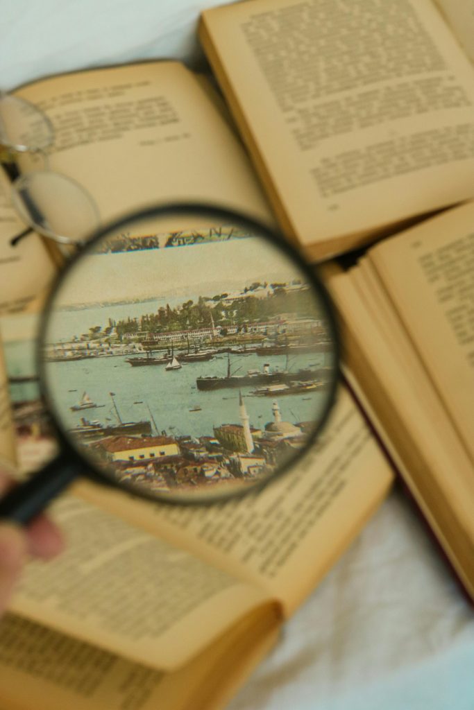 By Feyza Daştan from Pexels. A magnifying glass showing a picture of a port above open books. Used to illustrate how to choose keywords for your book.
