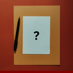 From Unsplash by Kelly Sikkema. A blank page with a question mark and a black pen to illustrate blog post 'how do I write a book?'